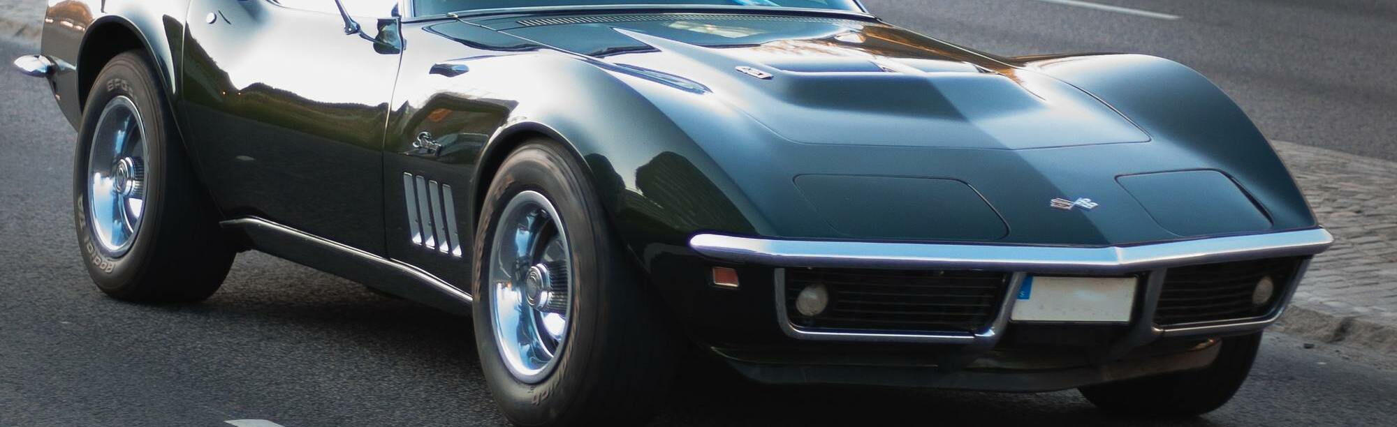 Black C4 Corvette driving on road during sunset